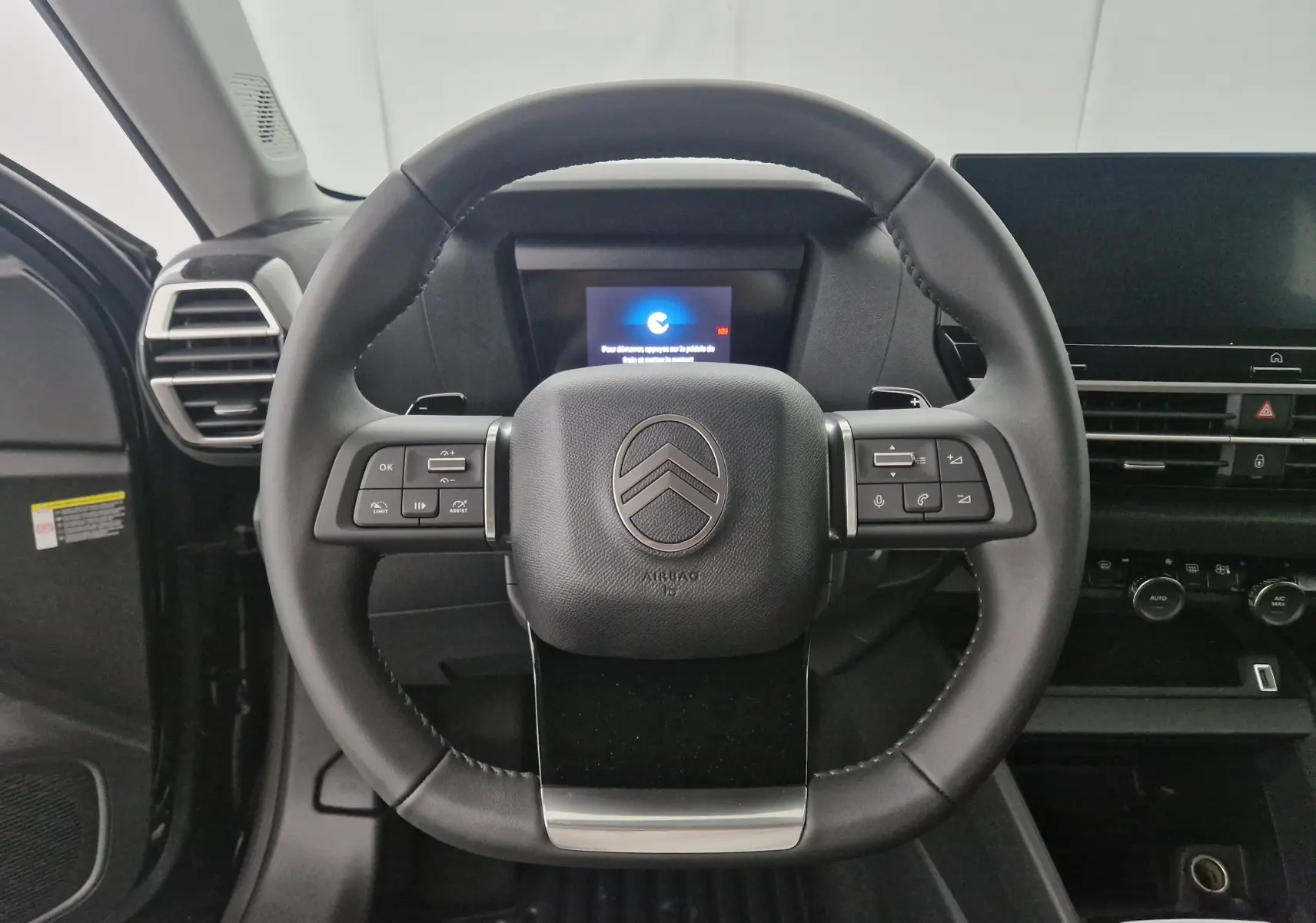 Volant en cuir noir de la Citroën C4 1.2 HYBRID 145 e-DSC6 PLUS 2025 avec commandes intégrées et tableau de bord numérique.