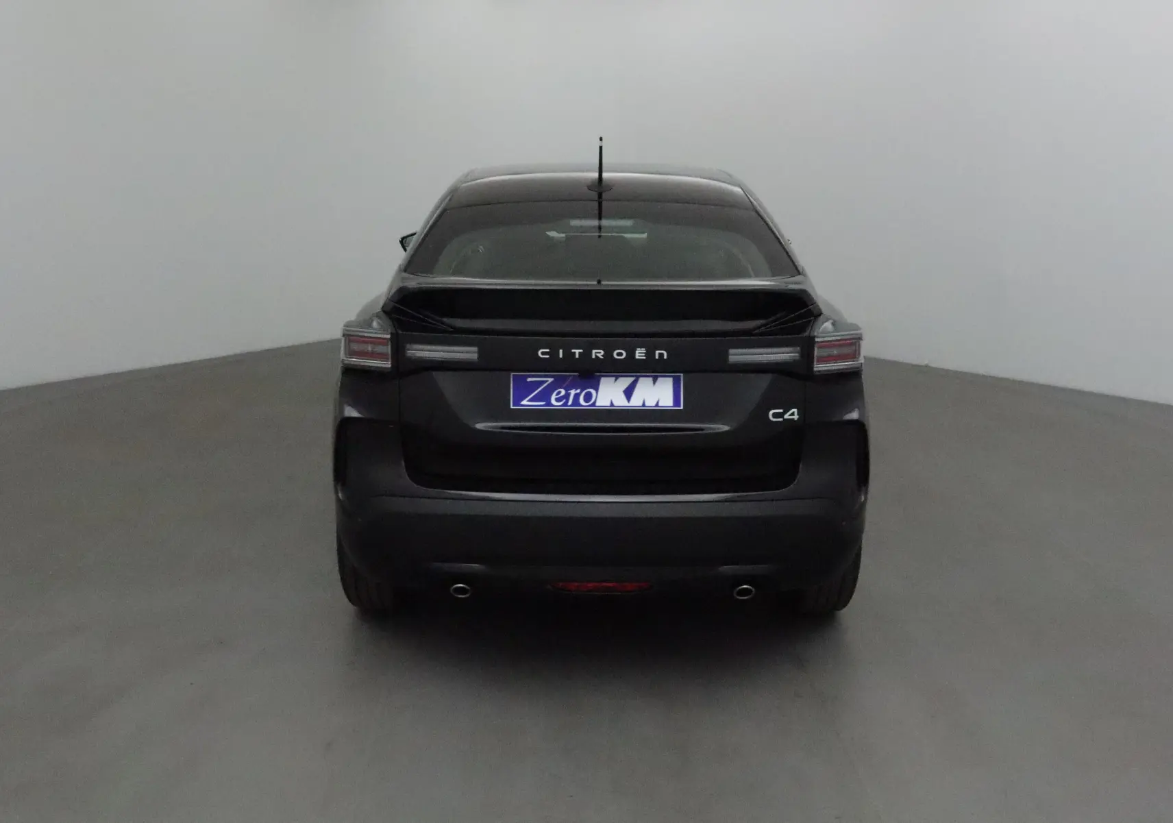 Vue arrière d'une Citroën C4 noire 2025 avec feux horizontaux et double sortie d'échappement visibles.