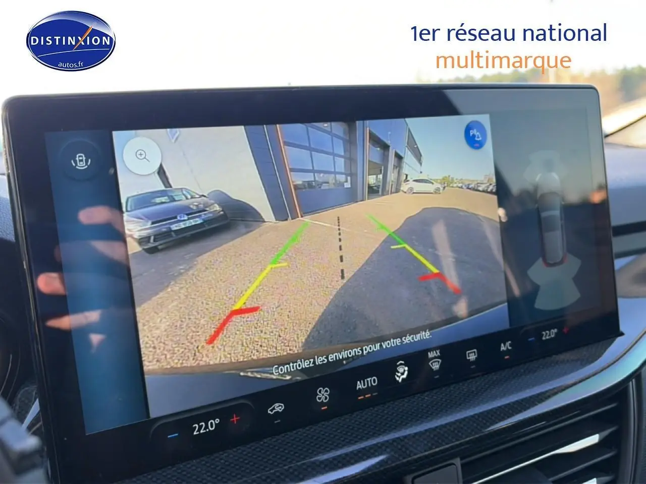 Écran tactile intérieur montrant la caméra de recul d'une Ford Focus noire 2024 avec lignes de guidage colorées.