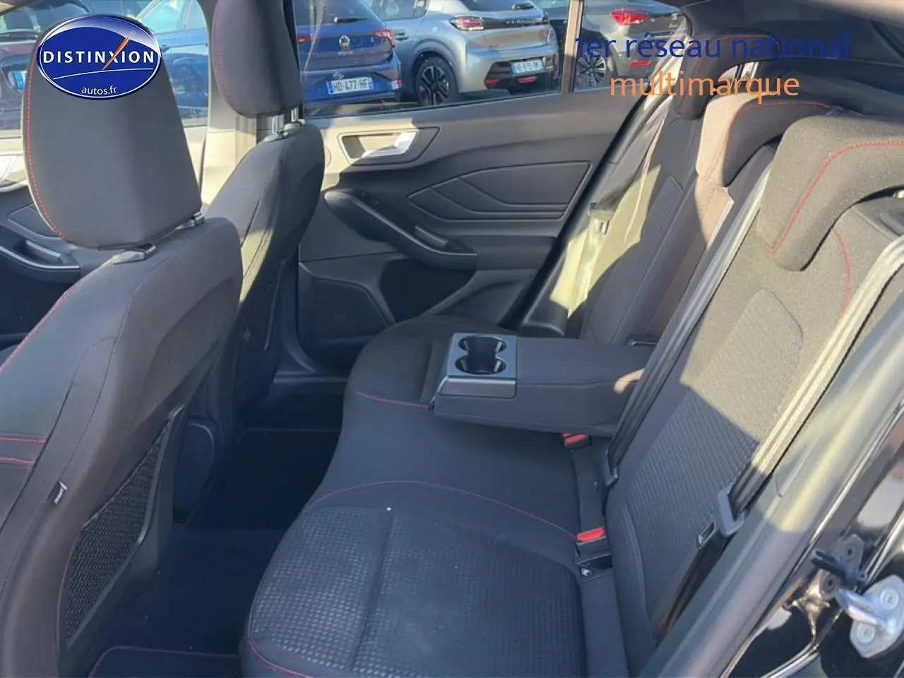 Vue intérieure côté droit de la banquette arrière noire avec accoudoir central et porte-gobelets de la Ford Focus 2024.