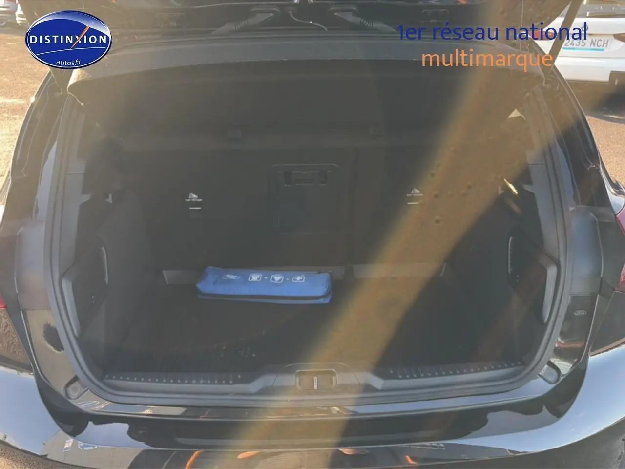 Coffre ouvert vu de l'arrière d'une Ford Focus noire 2024, avec trousse de secours bleue visible à l'intérieur.