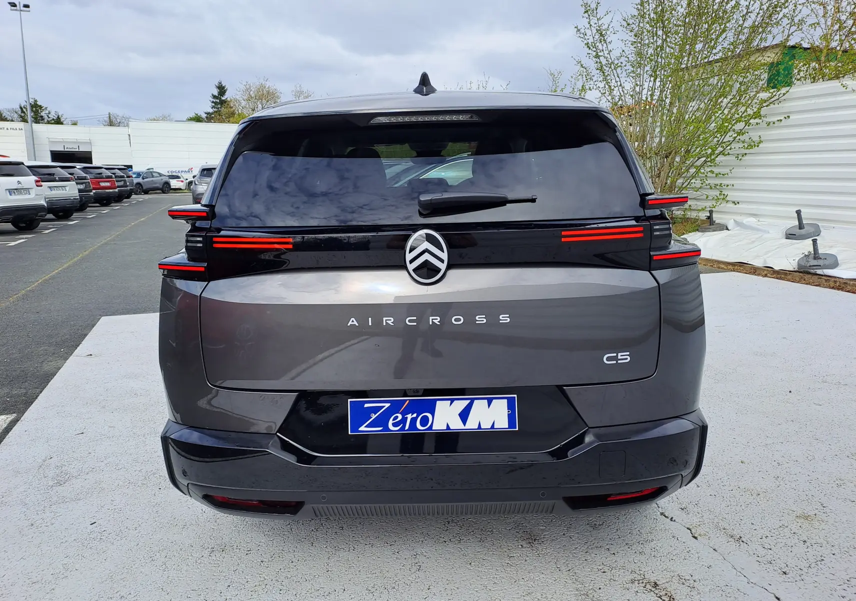 Vue arrière du Citroën C5 Aircross gris platinium avec toit noir, feux arrière LED distinctifs et logo centré.