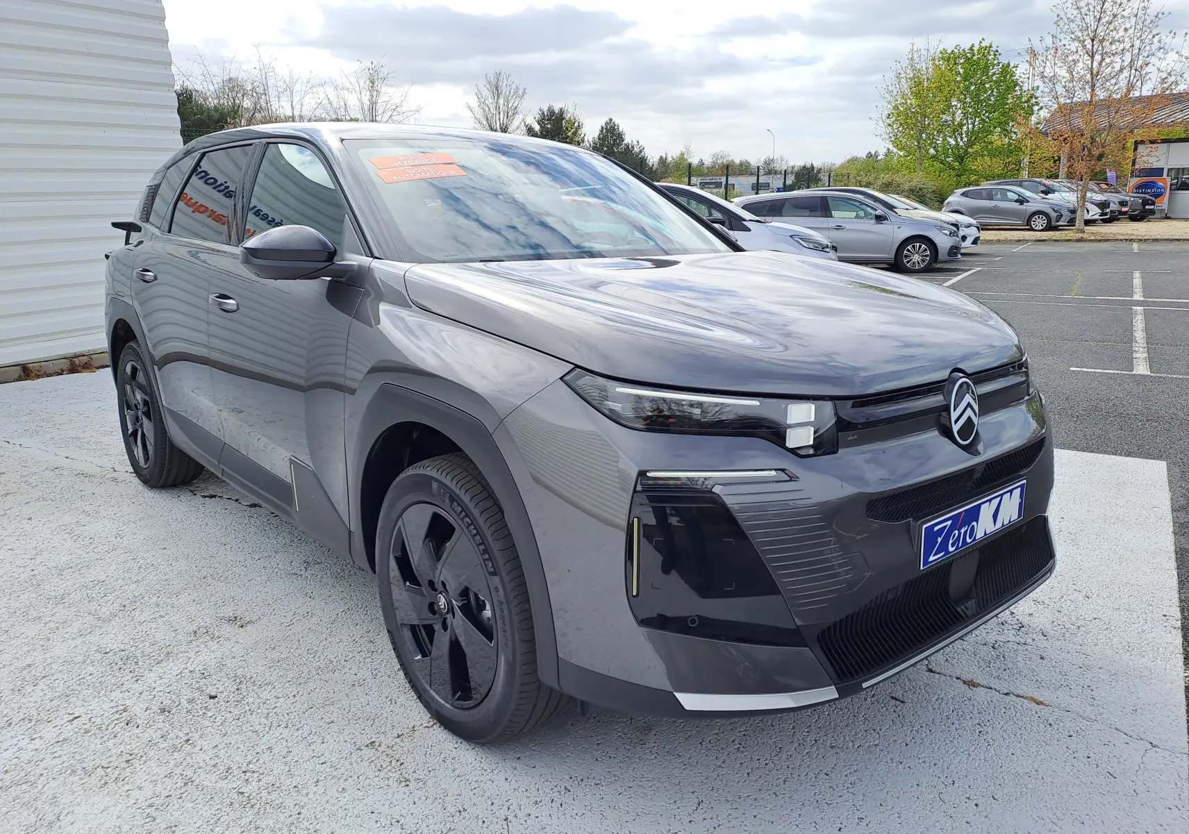 Citroën C5 Aircross gris platinium vue 3/4 avant droit, toit noir, calandre moderne et jantes noires.