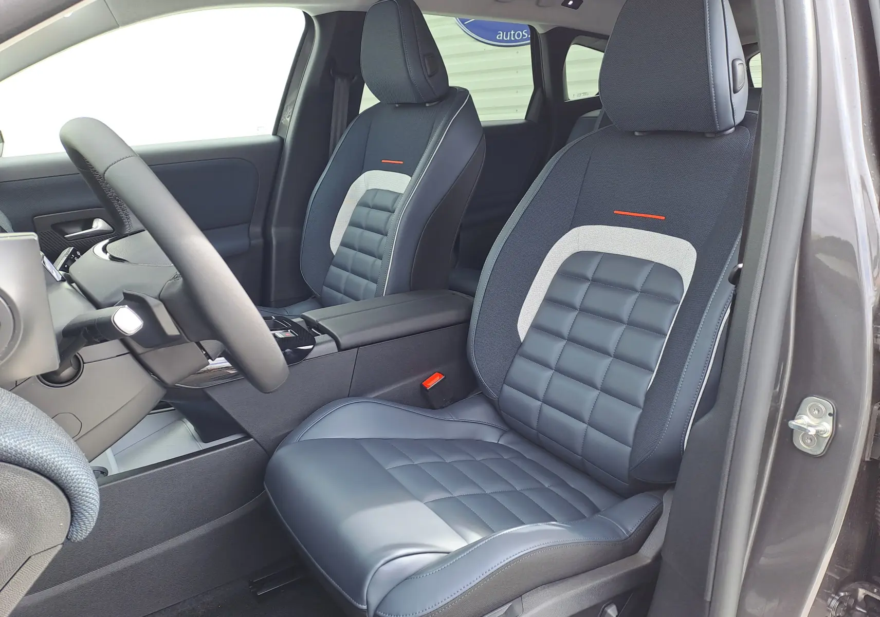 Vue intérieure côté conducteur du Citroën C5 Aircross 2026, sièges bi-matière gris et tissu avec surpiqûres contrastées.