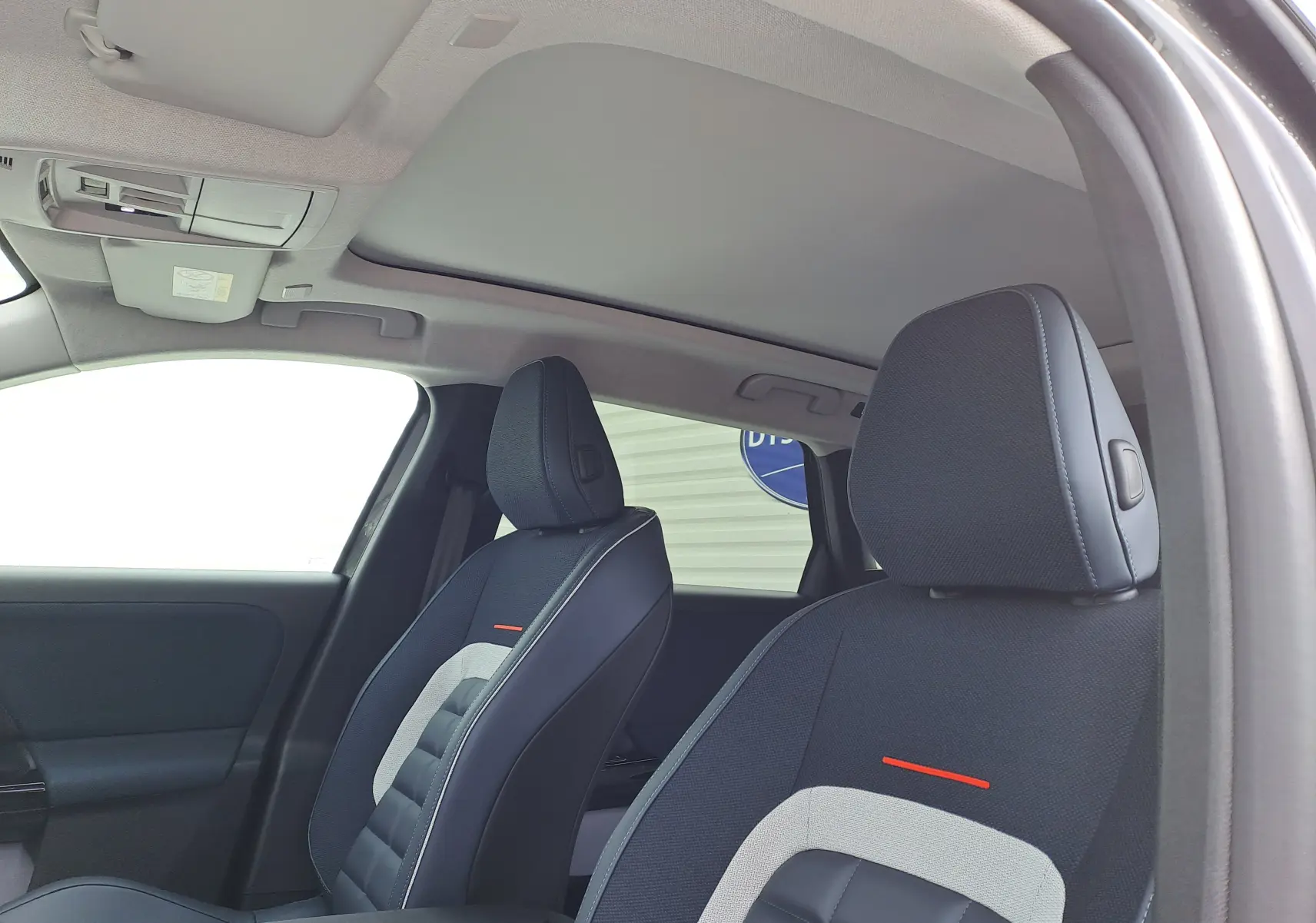 Vue intérieure côté droit du Citroën C5 Aircross 2026, sièges tissu et cuir gris foncé avec surpiqûres rouges.