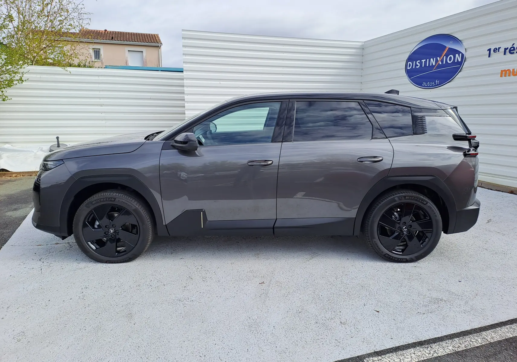 Vue de profil côté gauche d'un Citroën C5 Aircross gris platinium avec toit noir et jantes noires brillantes.