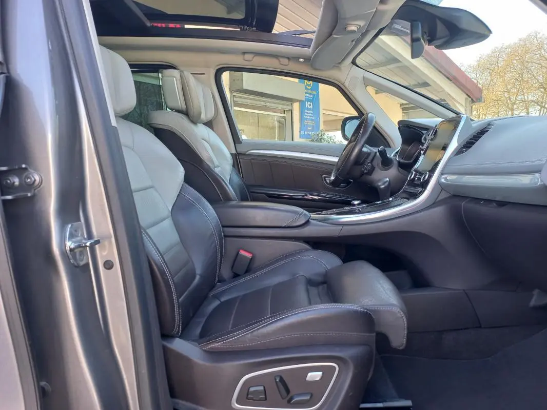 Vue intérieure côté conducteur du Renault Espace gris 2017, mettant en valeur les sièges cuir et la console centrale moderne.