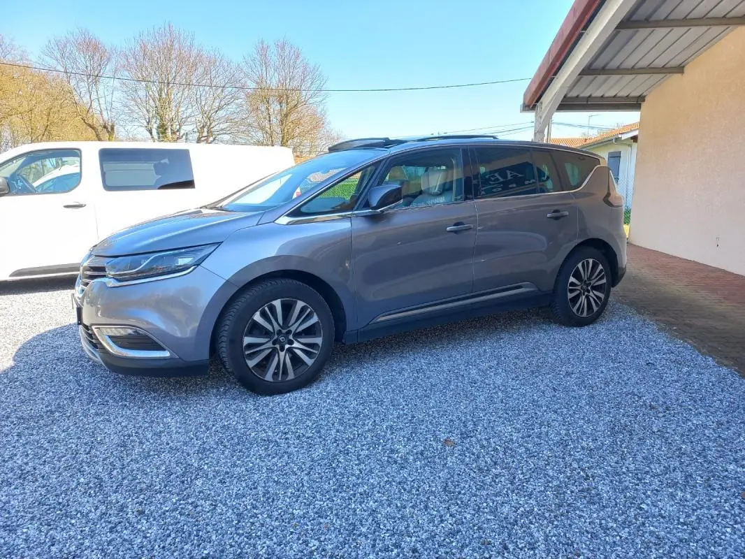 Renault Espace gris métallisé vu de profil côté gauche, avec jantes alliage et toit panoramique visible.