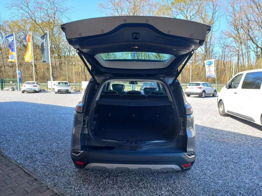 Vue arrière d’un Renault Espace gris 2017 avec coffre ouvert, montrant l’espace de chargement vide en extérieur.