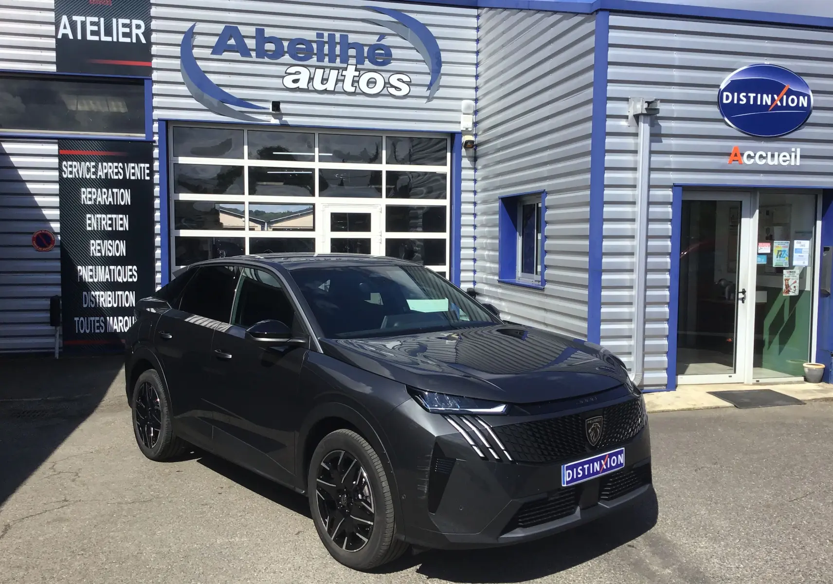 Peugeot 3008 gris titane en 3/4 avant droit devant un garage avec logo Abeilhé autos visible.