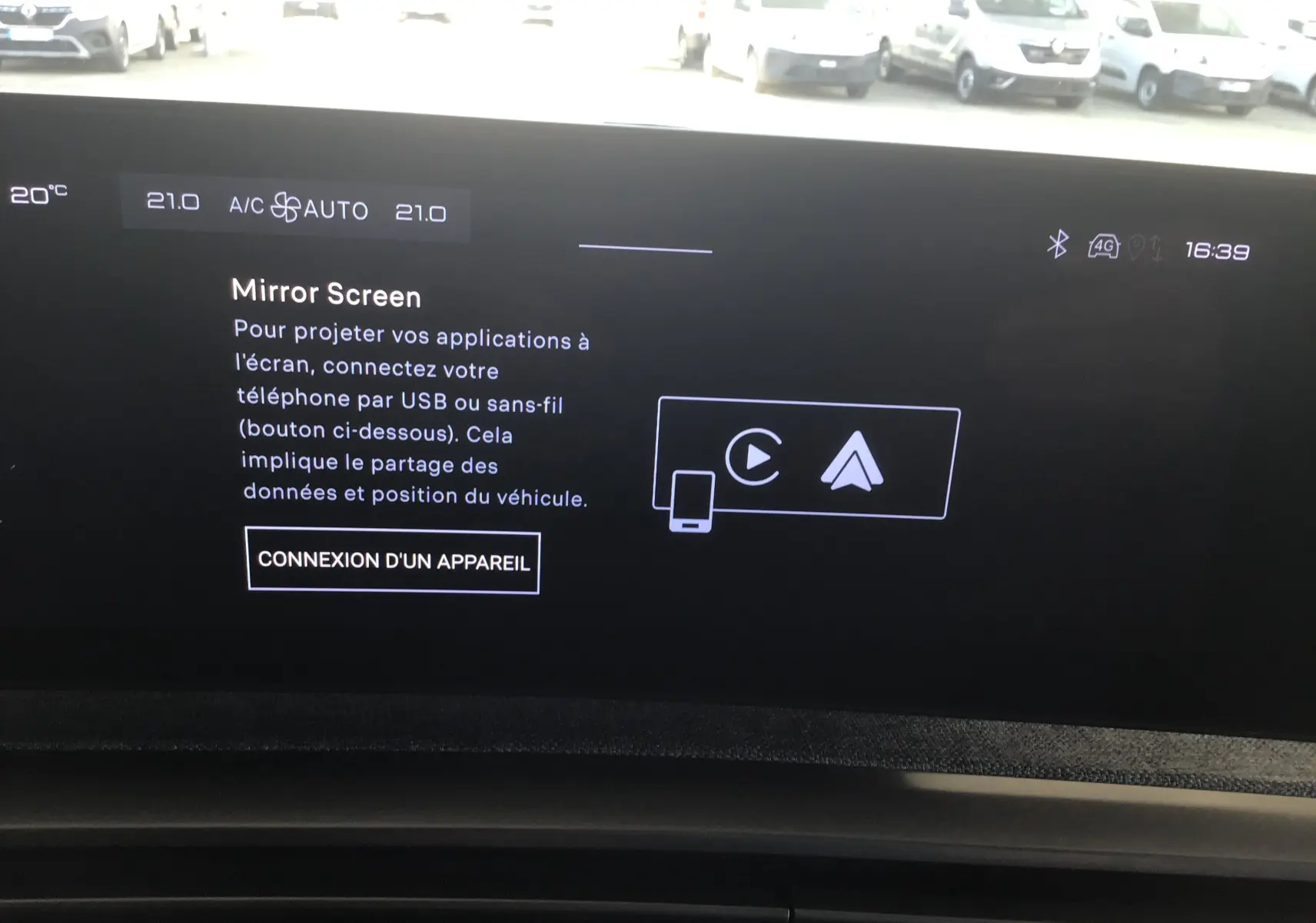 Gros plan sur le chargeur sans fil intégré au tableau de bord du Peugeot 3008 gris titane 2026.
