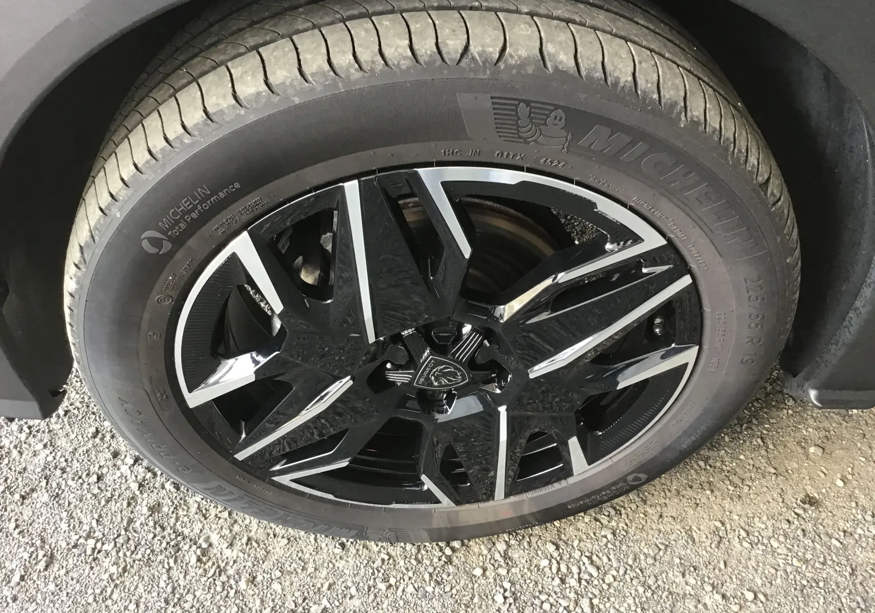 Vue plongeante sur le rangement central ouvert du Peugeot 3008 1.2 HYBRID 145 gris titane, intérieur noir avec surpiqûres claires.