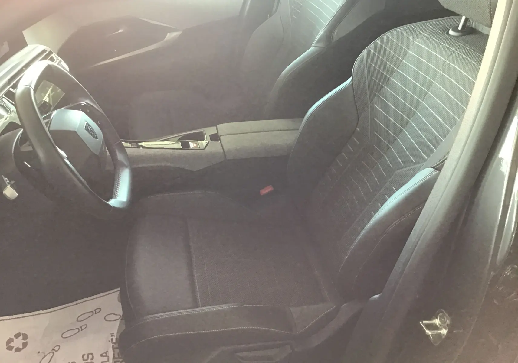 Vue intérieure côté conducteur du Peugeot 3008 gris titane 2026, sièges en tissu et cuir avec détails modernes.