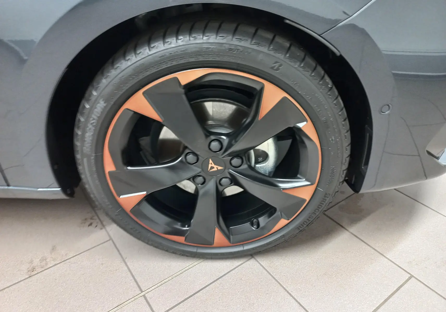 Gros plan sur la jante alliage 18'' cuivrée du côté avant droit d'une CUPRA Leon gris magnétique 2025.