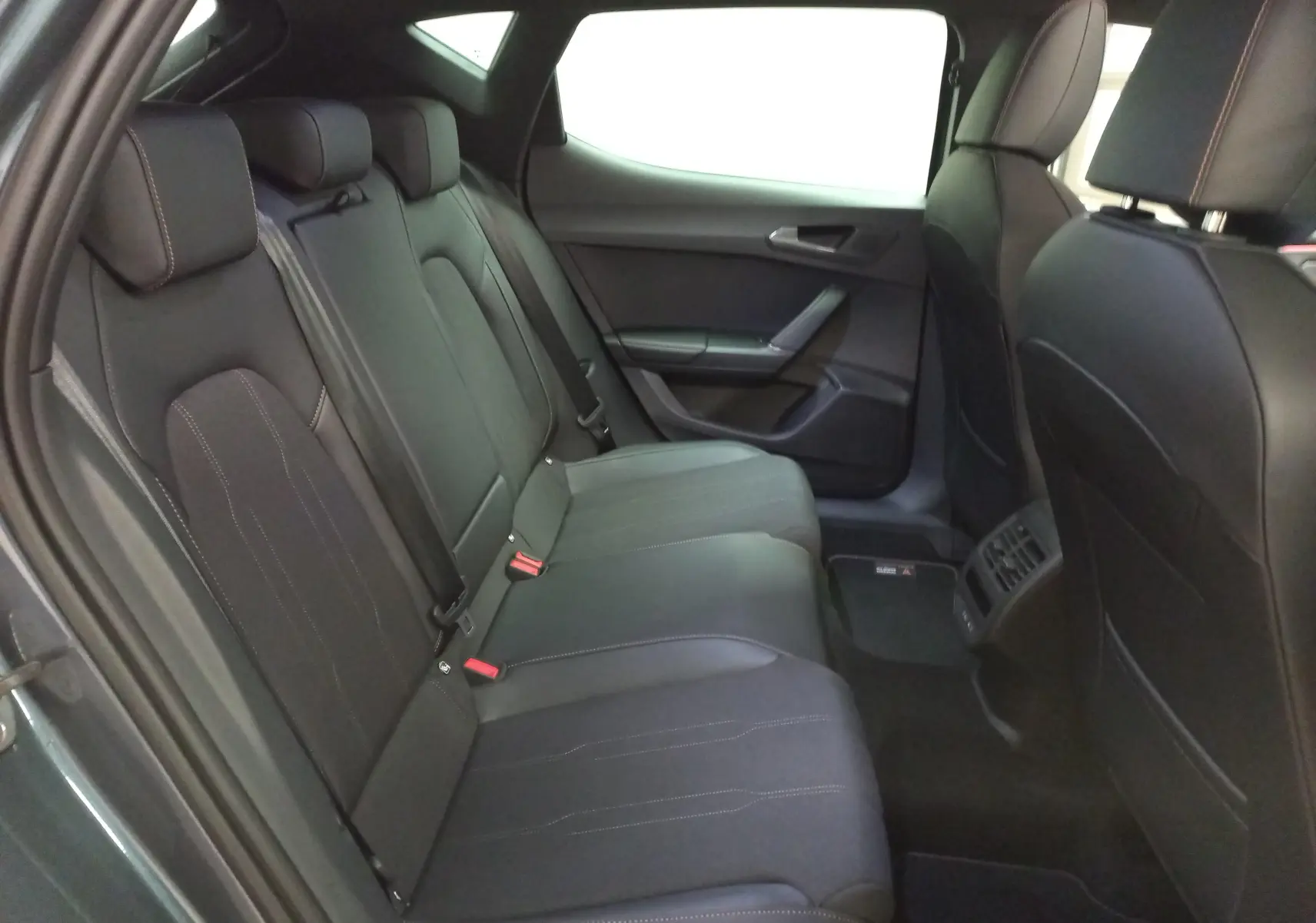 Vue intérieure côté gauche des sièges arrière noirs avec surpiqûres cuivrées d'une CUPRA Leon Ph.2 2025.