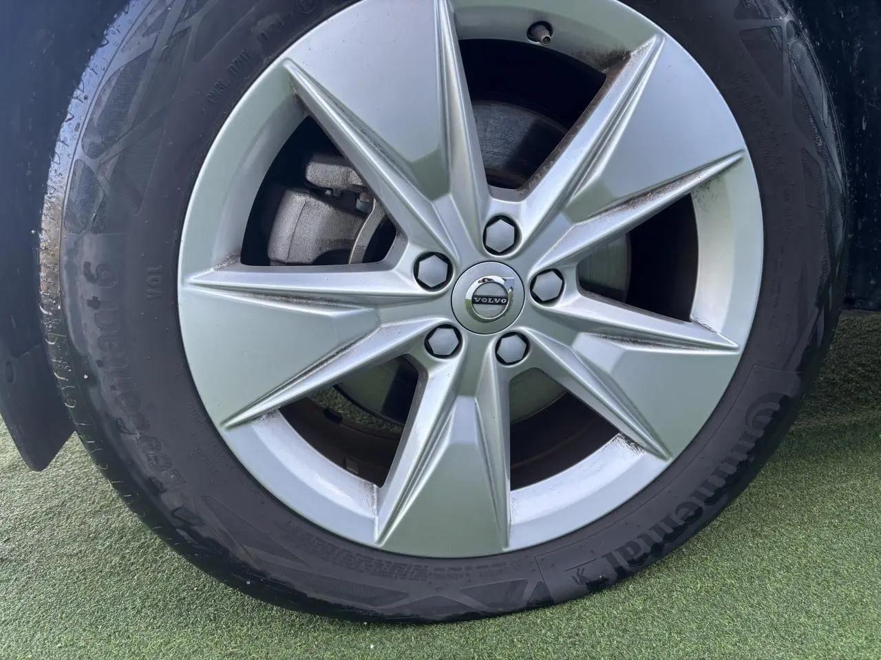 Gros plan sur la jante alliage 18 pouces argentée avec logo Volvo au centre du Volvo XC40 Fjord Blue.