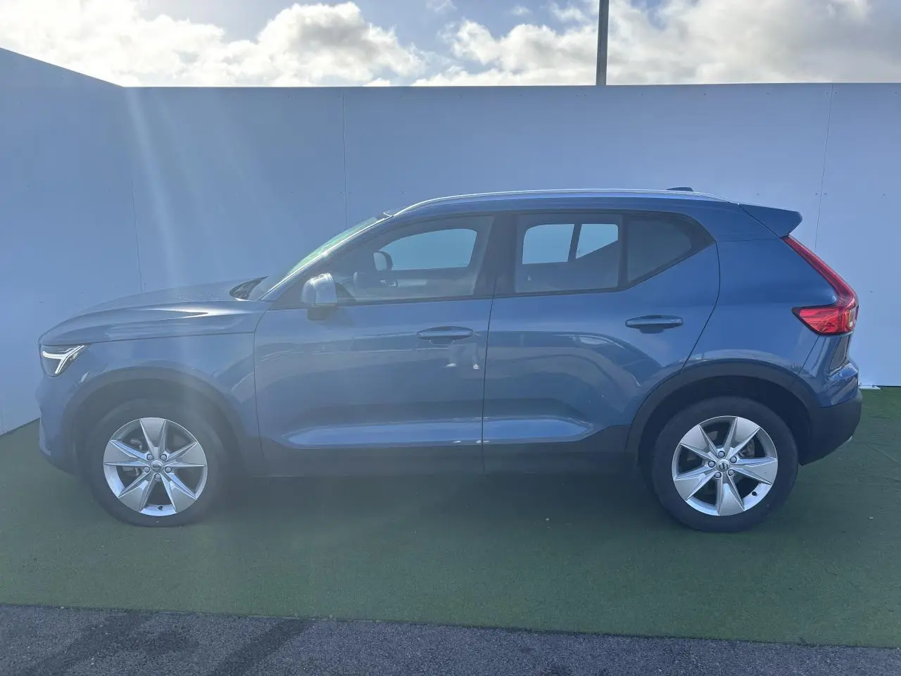Profil côté gauche d'un Volvo XC40 Fjord Blue Metal 2024 avec jantes alliage 18 pouces et feux arrière LED.