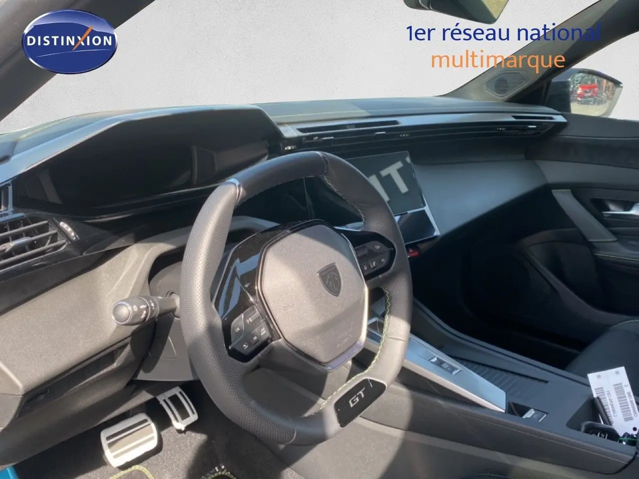 Vue intérieure côté conducteur du Peugeot 308 Hybrid 145ch GT 2026, volant cuir noir avec badge GT et tableau de bord moderne.