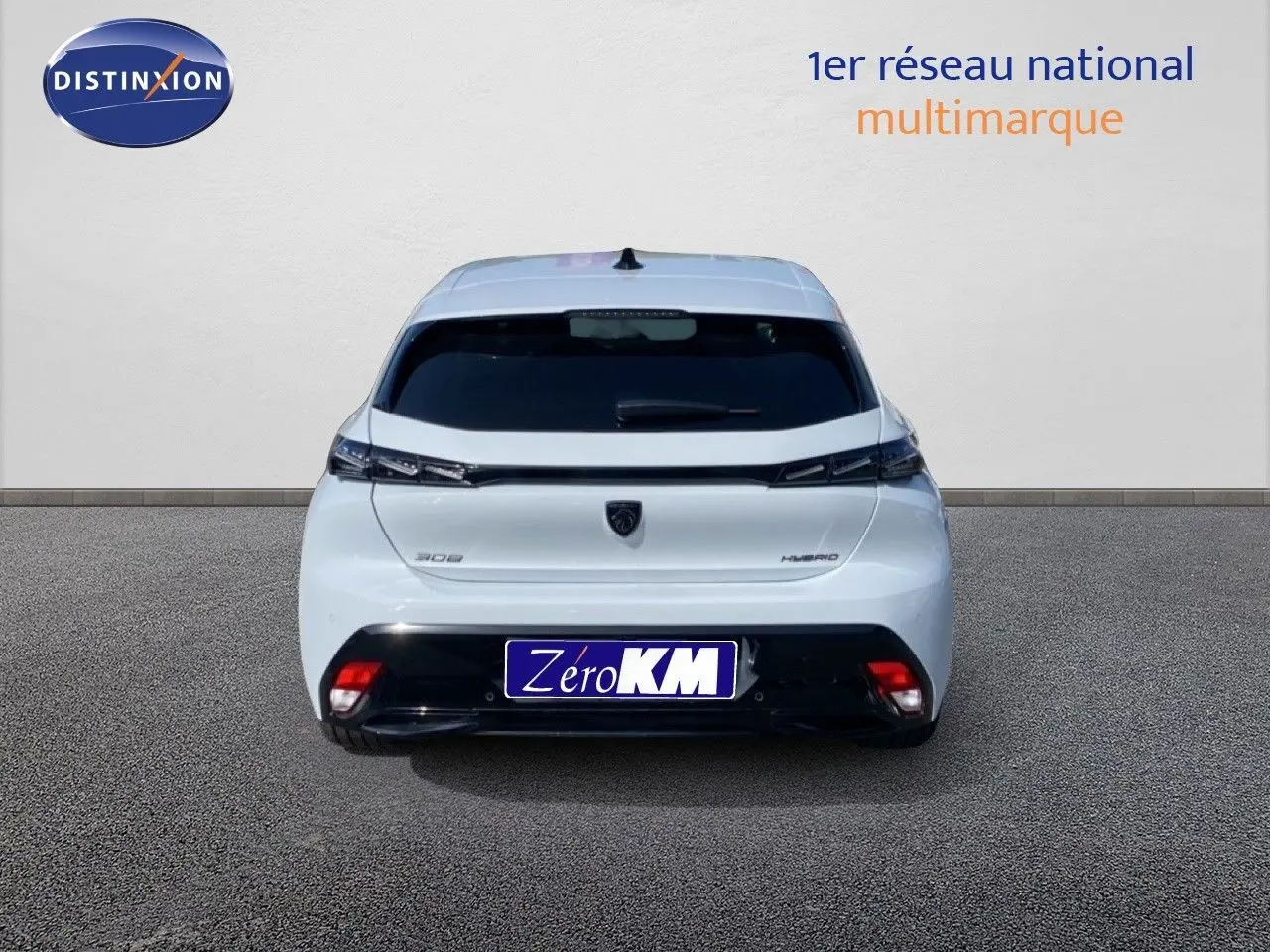 Vue arrière d'une Peugeot 308 Hybrid blanche Okenite Metal avec feux effilés et logo noir central.