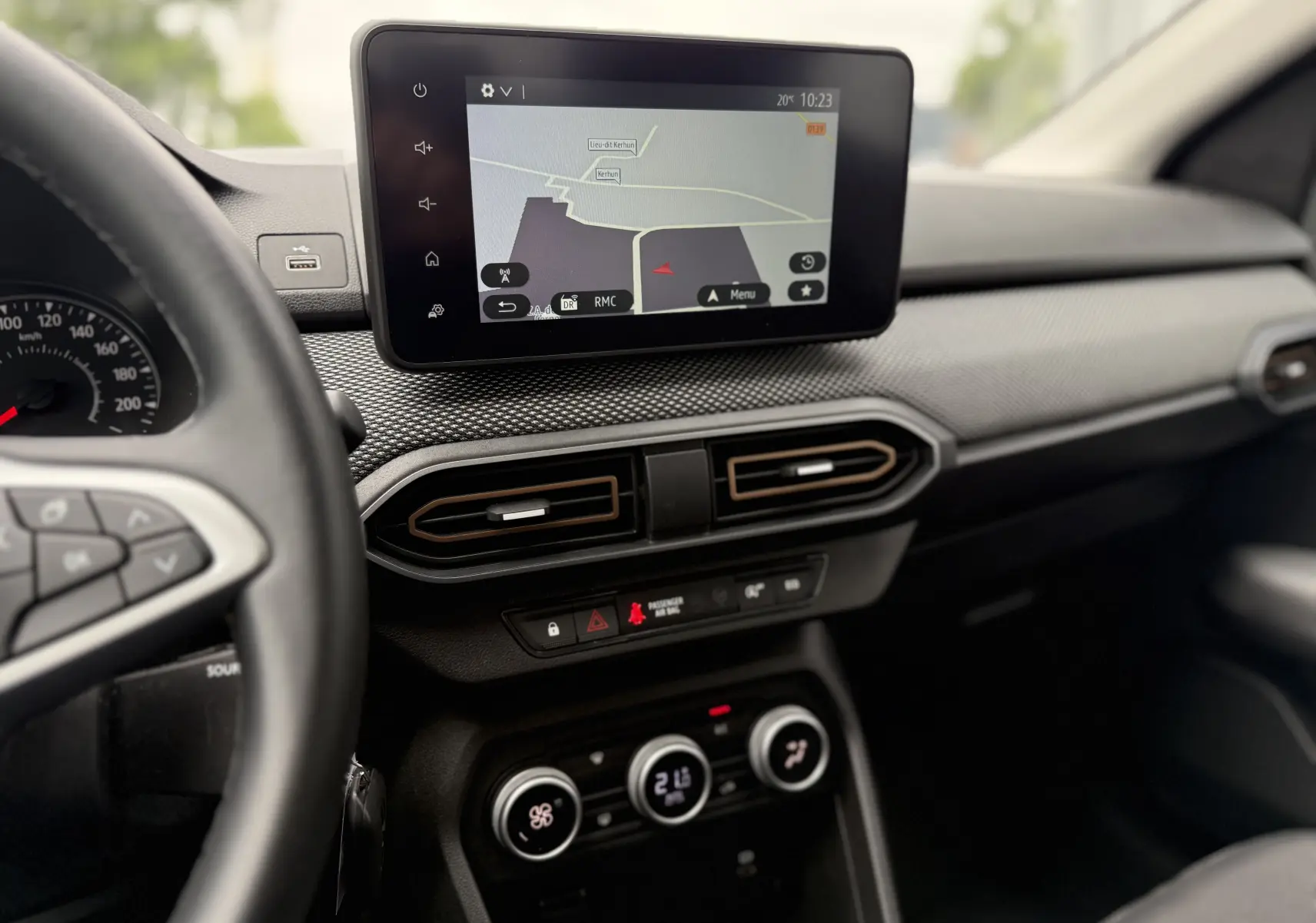 Vue intérieure du tableau de bord de la Dacia Sandero Stepway 2025, avec écran tactile de navigation et commandes de climatisation.