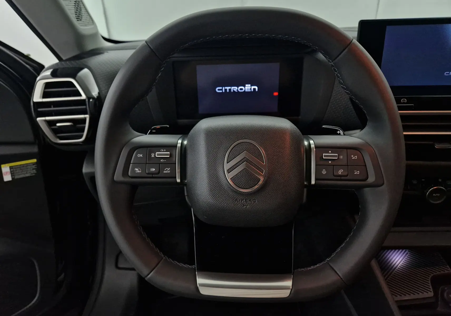 Volant en cuir noir de la Citroën C4 1.2 HYBRID 136 e-DSC6 MAX 2025 avec commandes intégrées et tableau de bord digital.