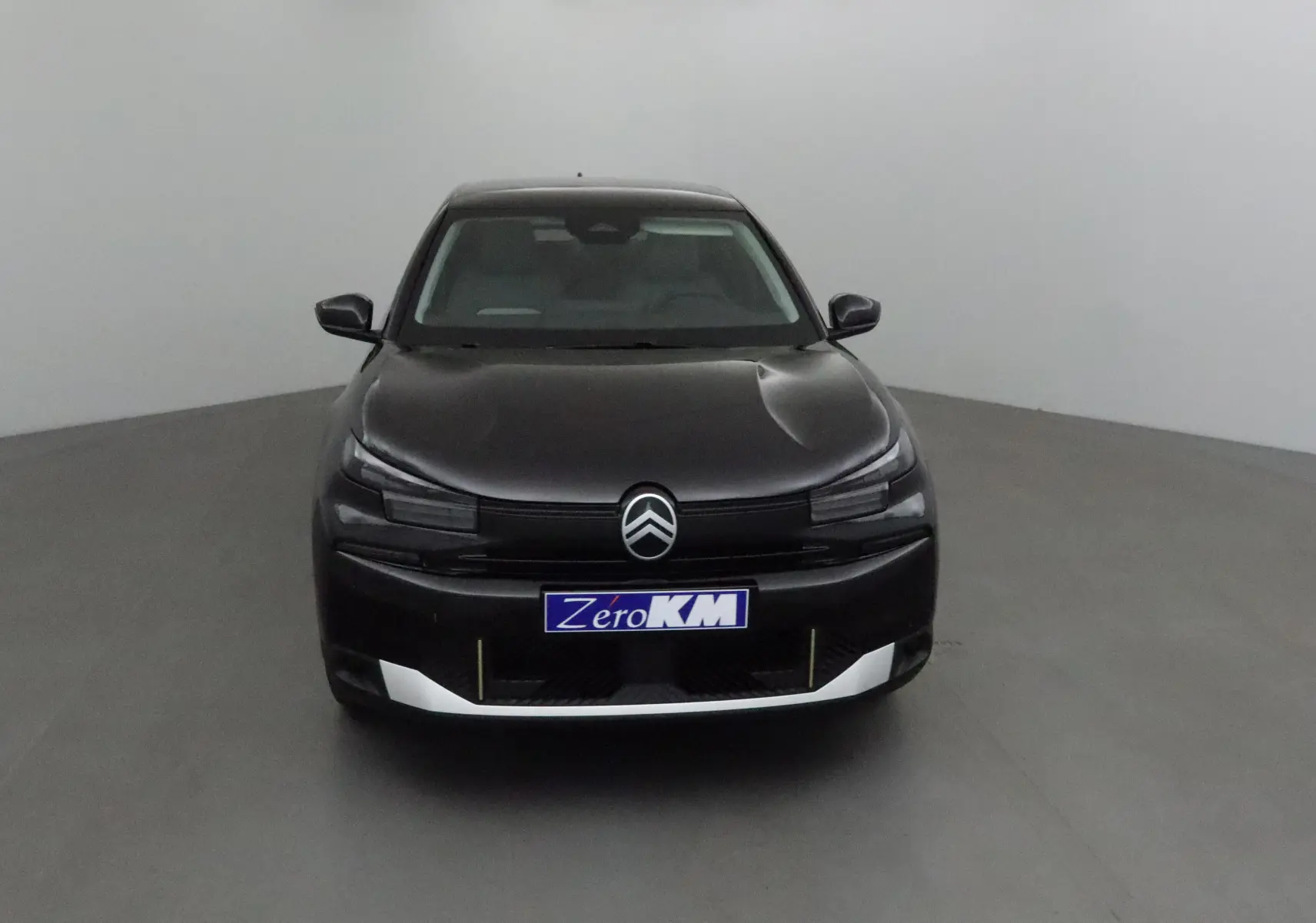 Vue frontale d'une Citroën C4 noire 2025 avec calandre épurée et logo chevrons bien visible.