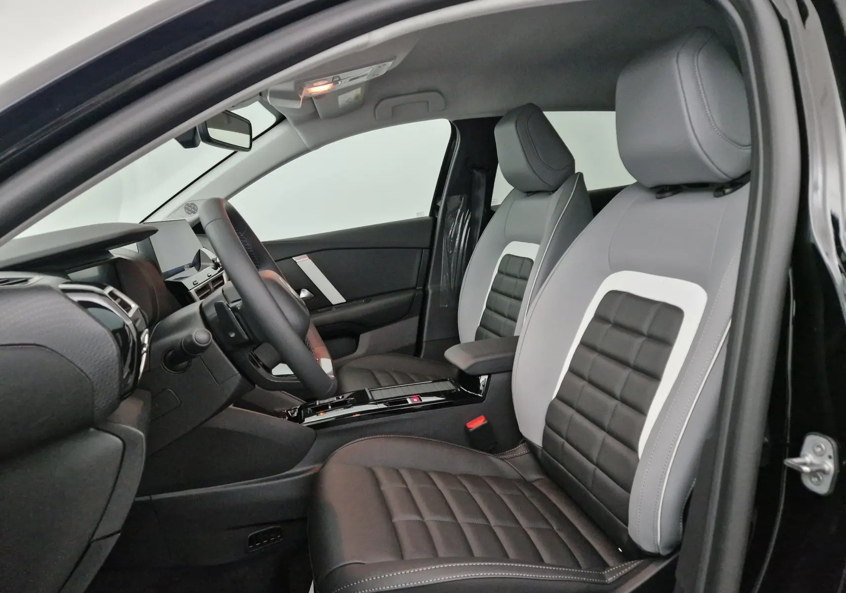 Intérieur de la Citroën C4 1.2 Hybrid 136 e-DSC6 Max 2025 en noir, vue côté conducteur sur sièges cuir bicolores.