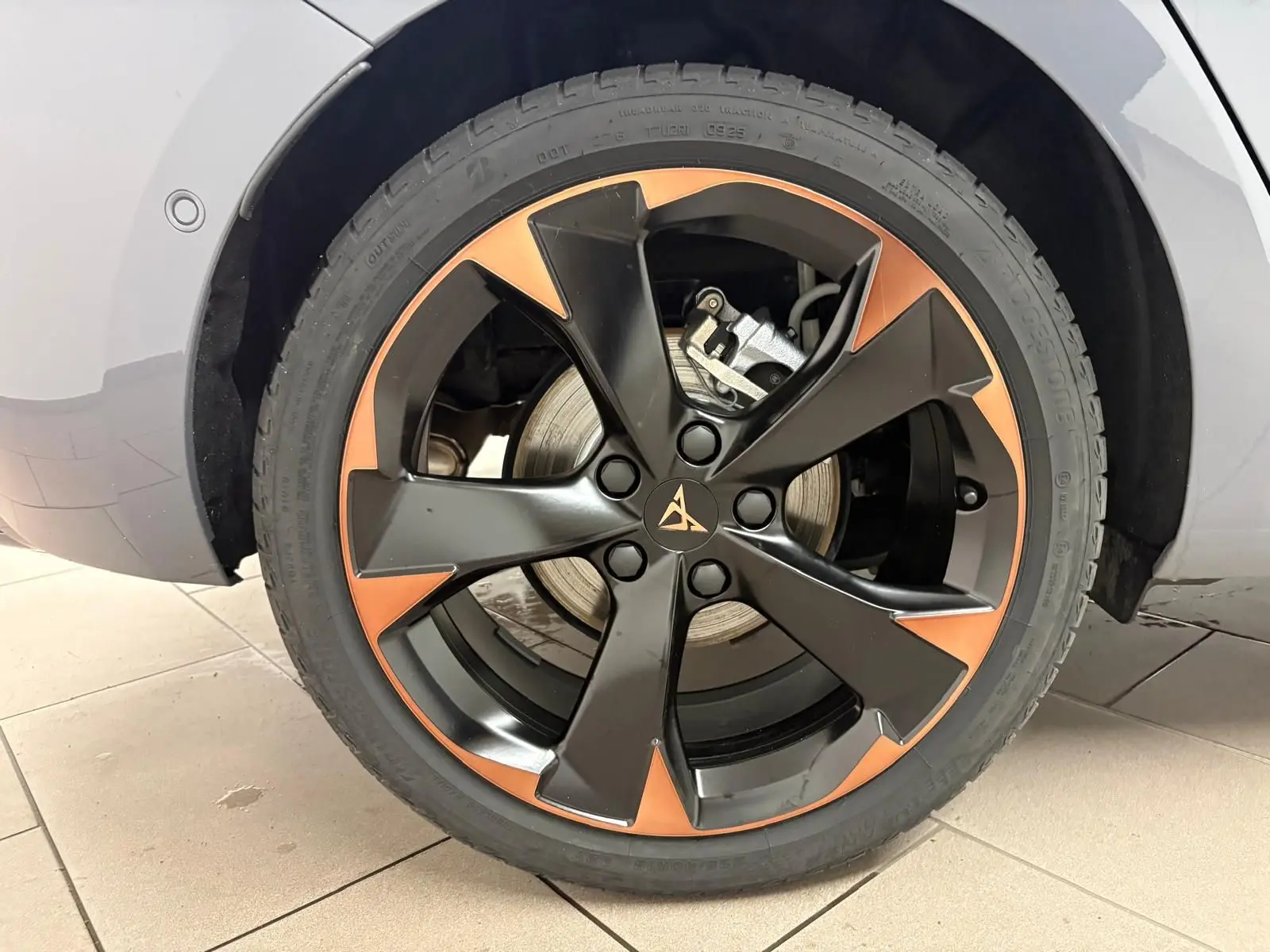 Gros plan sur la jante 18'' cuivrée et noire du côté arrière droit d'une CUPRA Leon gris Graphène.