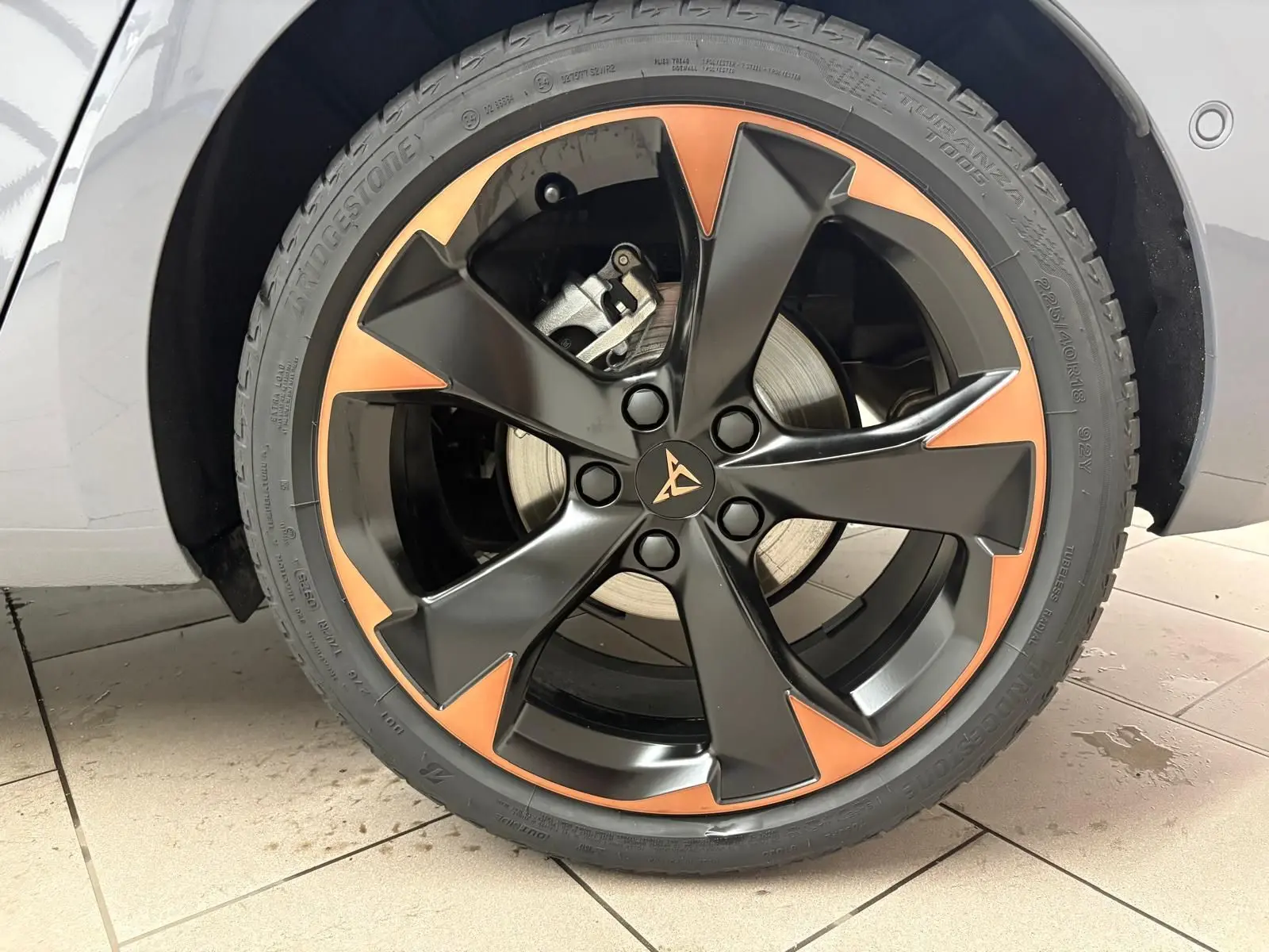 Gros plan sur la jante 18 pouces cuivrée et noire d'une CUPRA Leon gris Graphène, côté gauche avant.