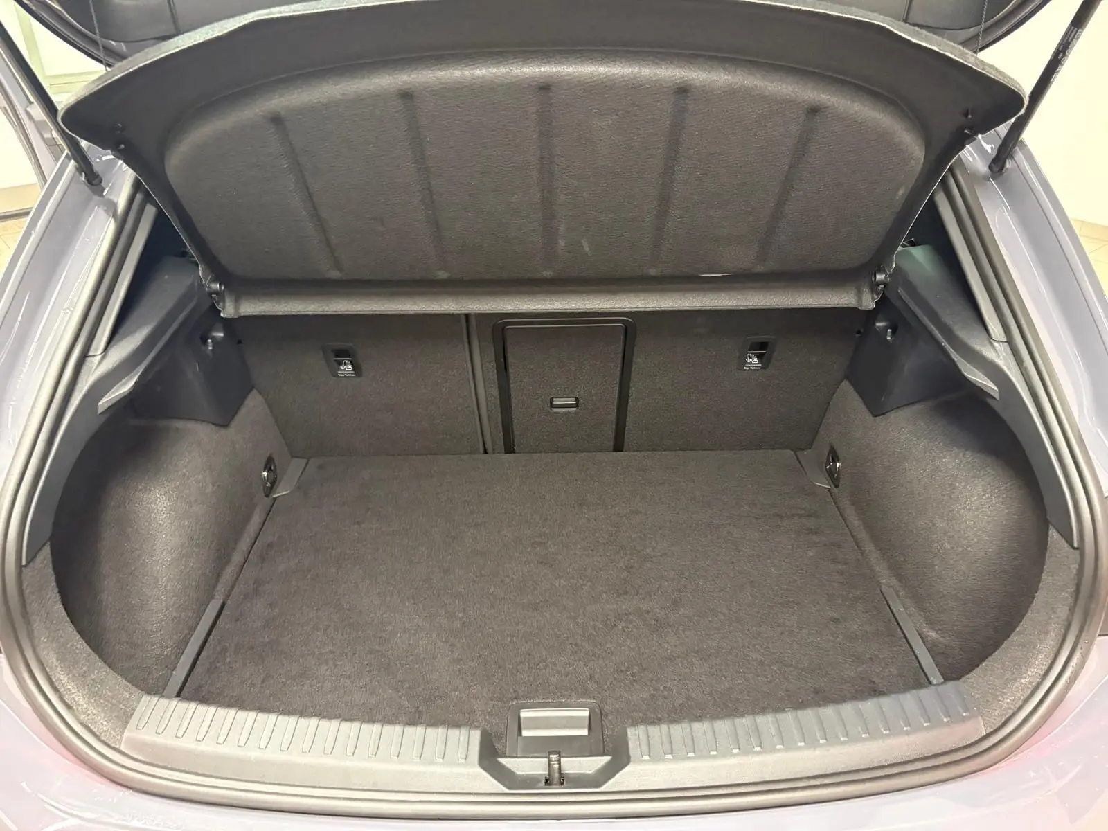 Coffre ouvert vu de l'arrière d'une CUPRA Leon gris Graphène, montrant un espace de chargement propre et spacieux.
