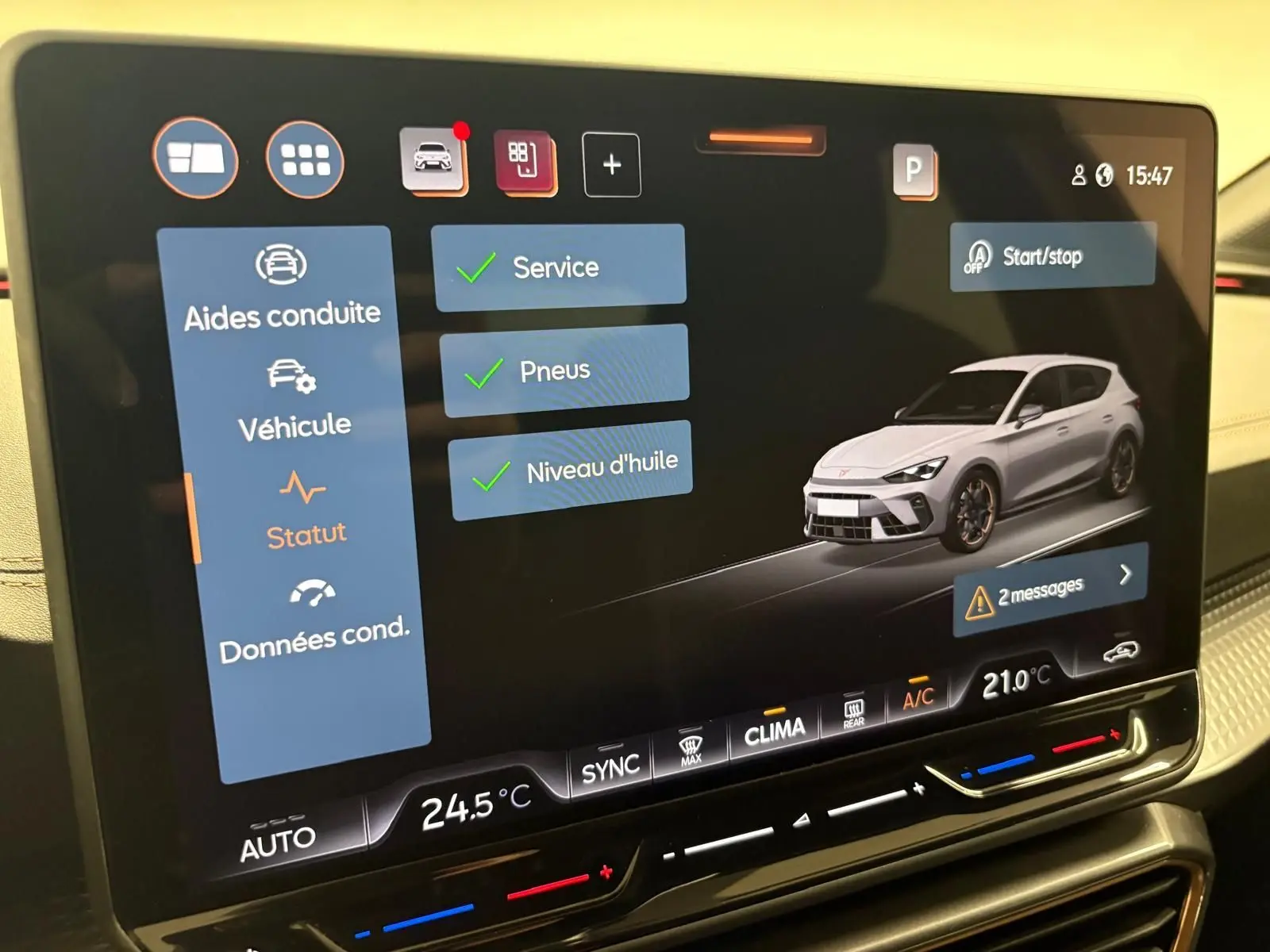 Écran tactile central affichant le menu d’aides à la conduite avec une modélisation 3D d’une CUPRA Leon gris clair en vue 3/4 avant.