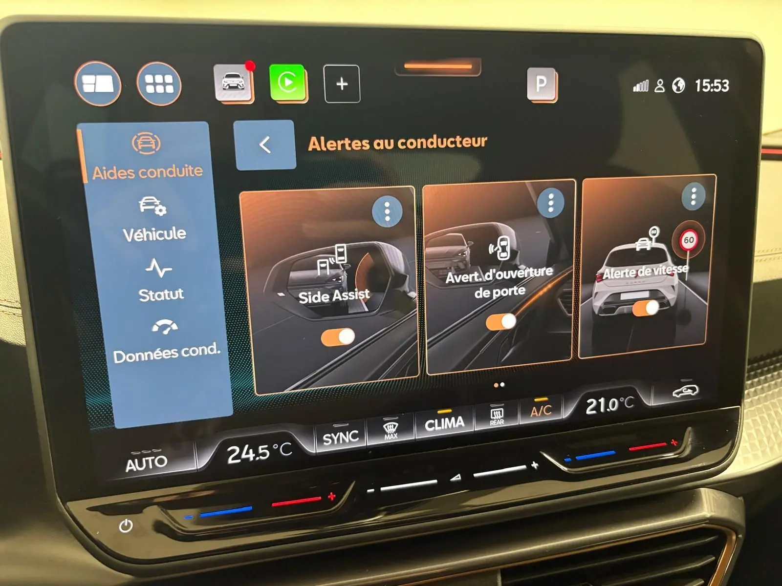 Écran tactile du tableau de bord de la CUPRA Leon 2025 affichant les alertes au conducteur et la climatisation.