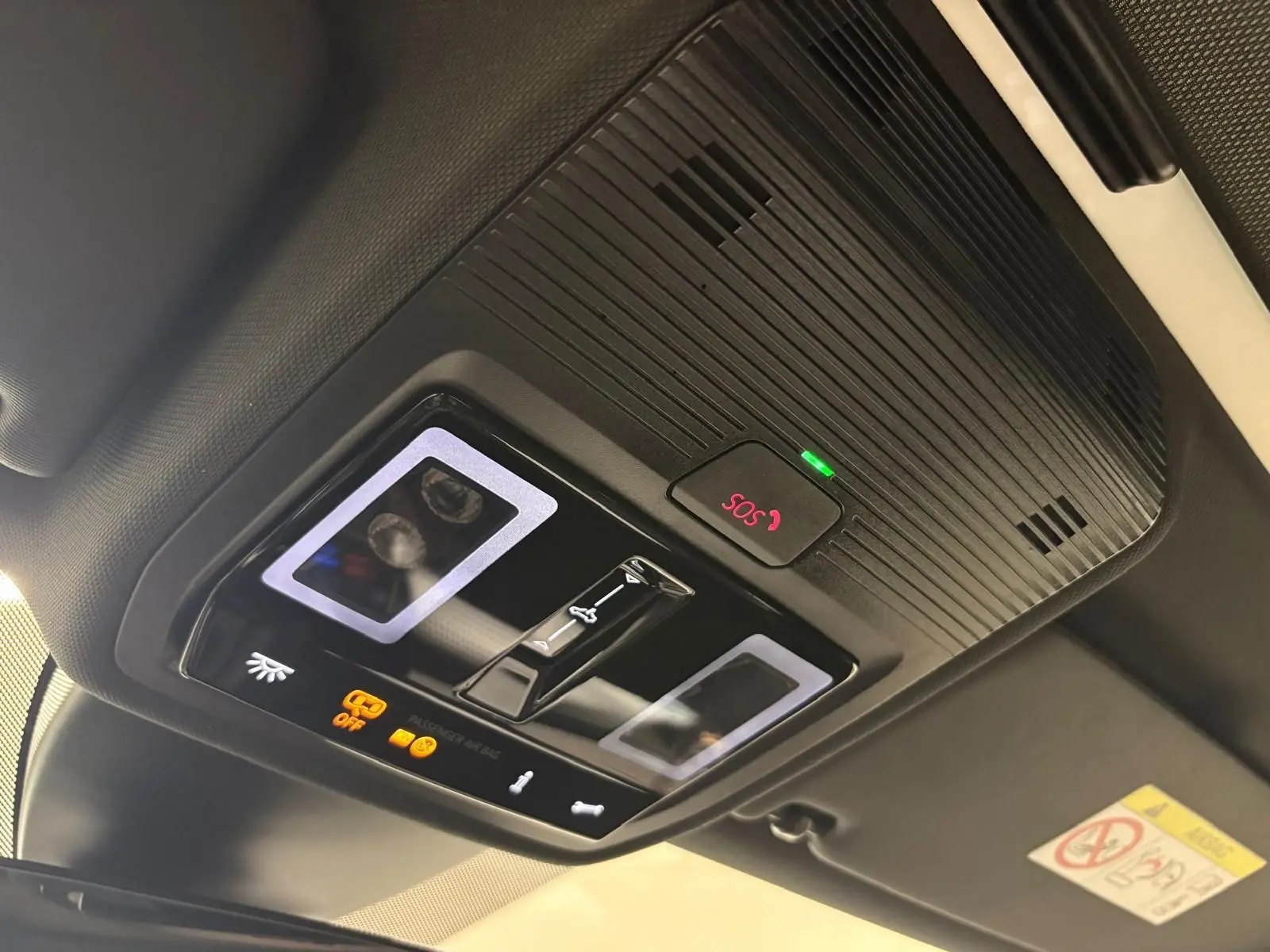 Vue en contre-plongée du panneau de commande intérieur noir avec bouton SOS et éclairage LED sur toit ouvrant d'une CUPRA Leon 2025.