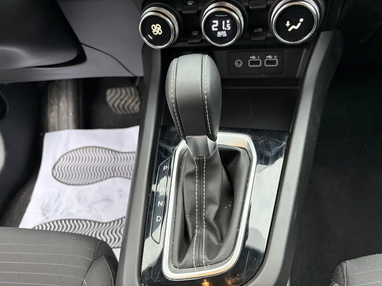 Gros plan sur la commande de la boîte automatique et les réglages de climatisation du Renault Arkana 2025.