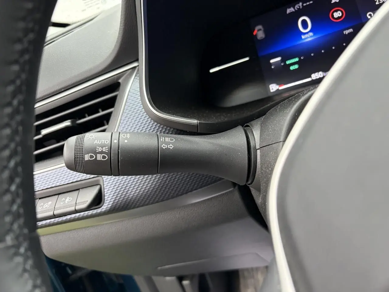 Gros plan sur la commande des feux et clignotants à gauche du volant du Renault Arkana bleu Zanzibar 2025.