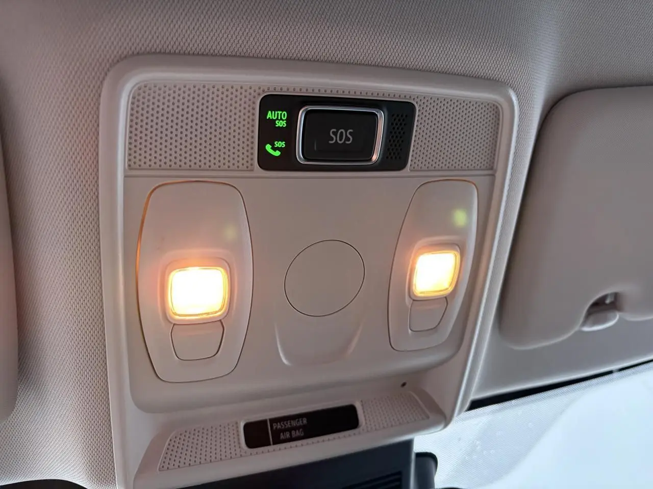 Vue intérieure du plafonnier avant avec éclairages allumés et bouton SOS du Renault Arkana bleu Zanzibar 2025.