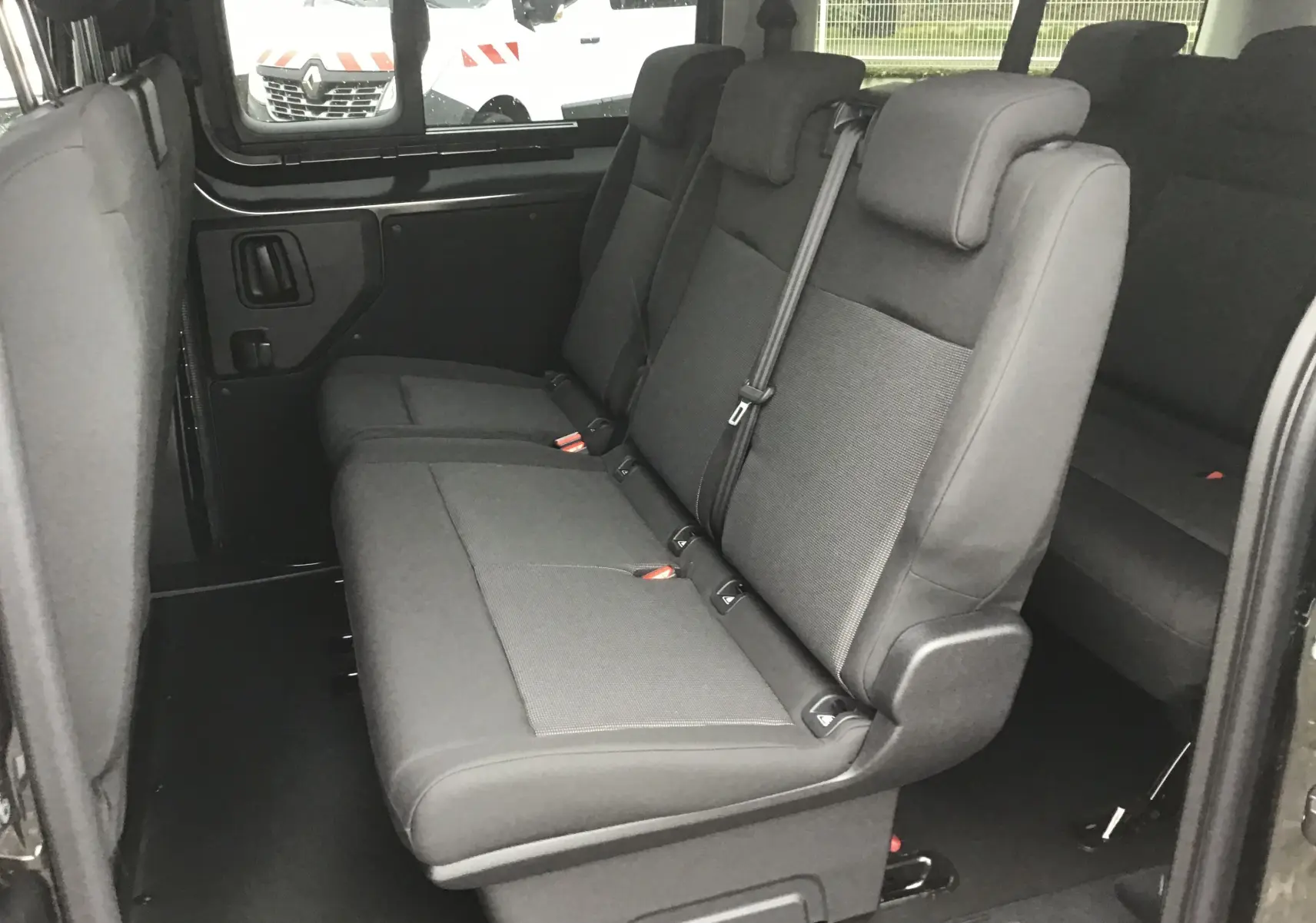 Vue intérieure côté droit montrant les sièges gris foncé du rang 2 du FIAT Scudo Combi XL 2026, avec vitres latérales coulissantes.