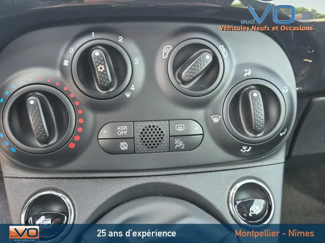 Gros plan sur les commandes de climatisation manuelle du tableau de bord d'une FIAT 500C noire 2024.