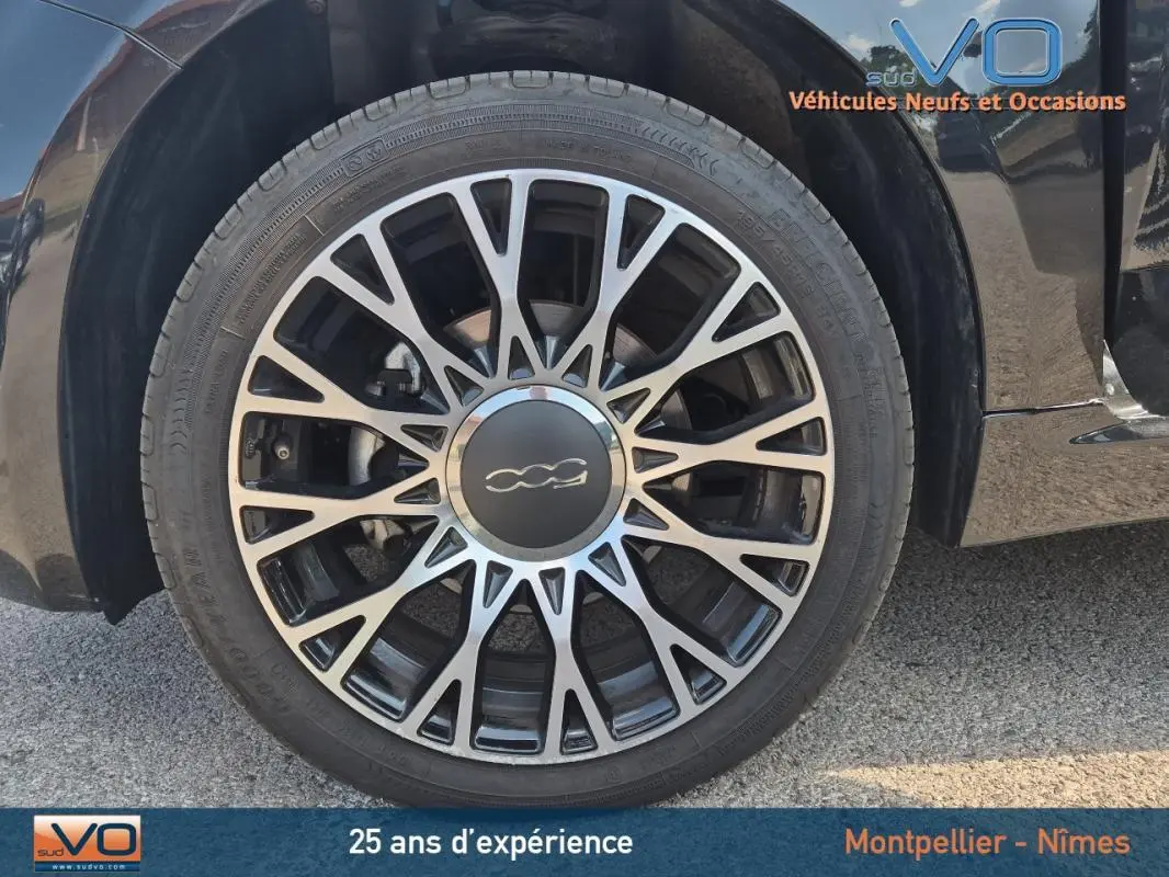 Gros plan sur la jante alliage 15 pouces noire et argentée du côté gauche d'une FIAT 500C noire 2024.