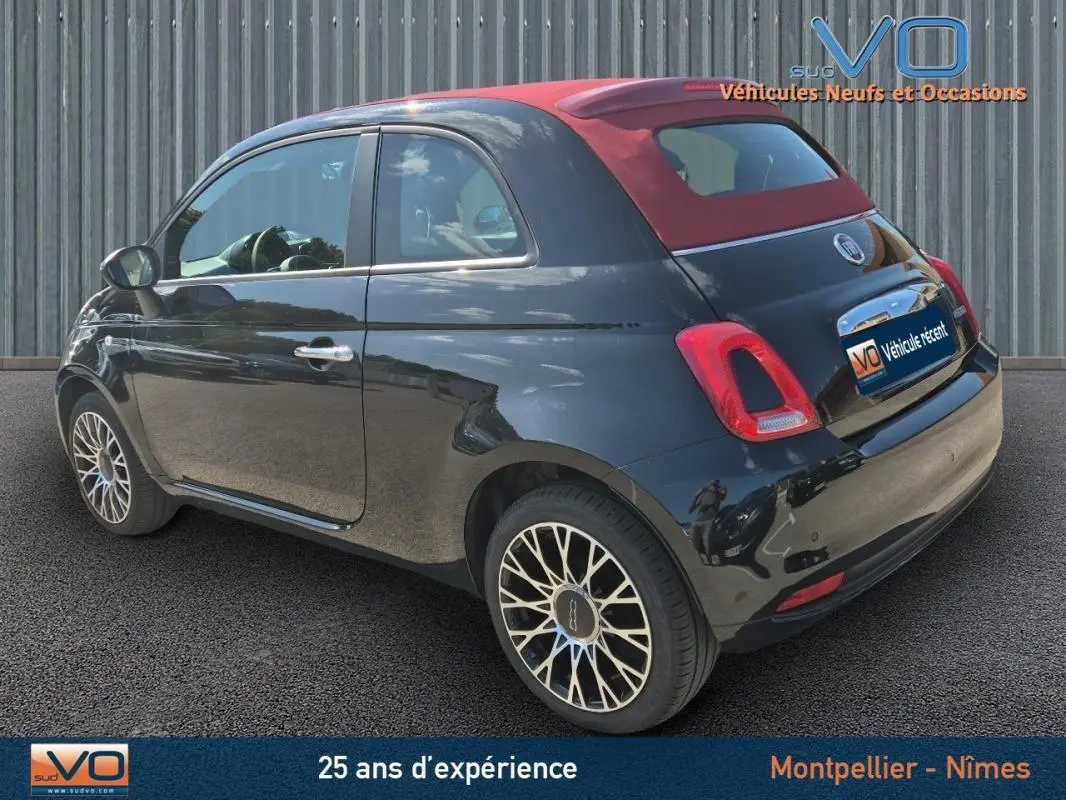 Fiat 500C noire vue 3/4 arrière droit avec toit rouge en toile et jantes alliage 15 pouces.