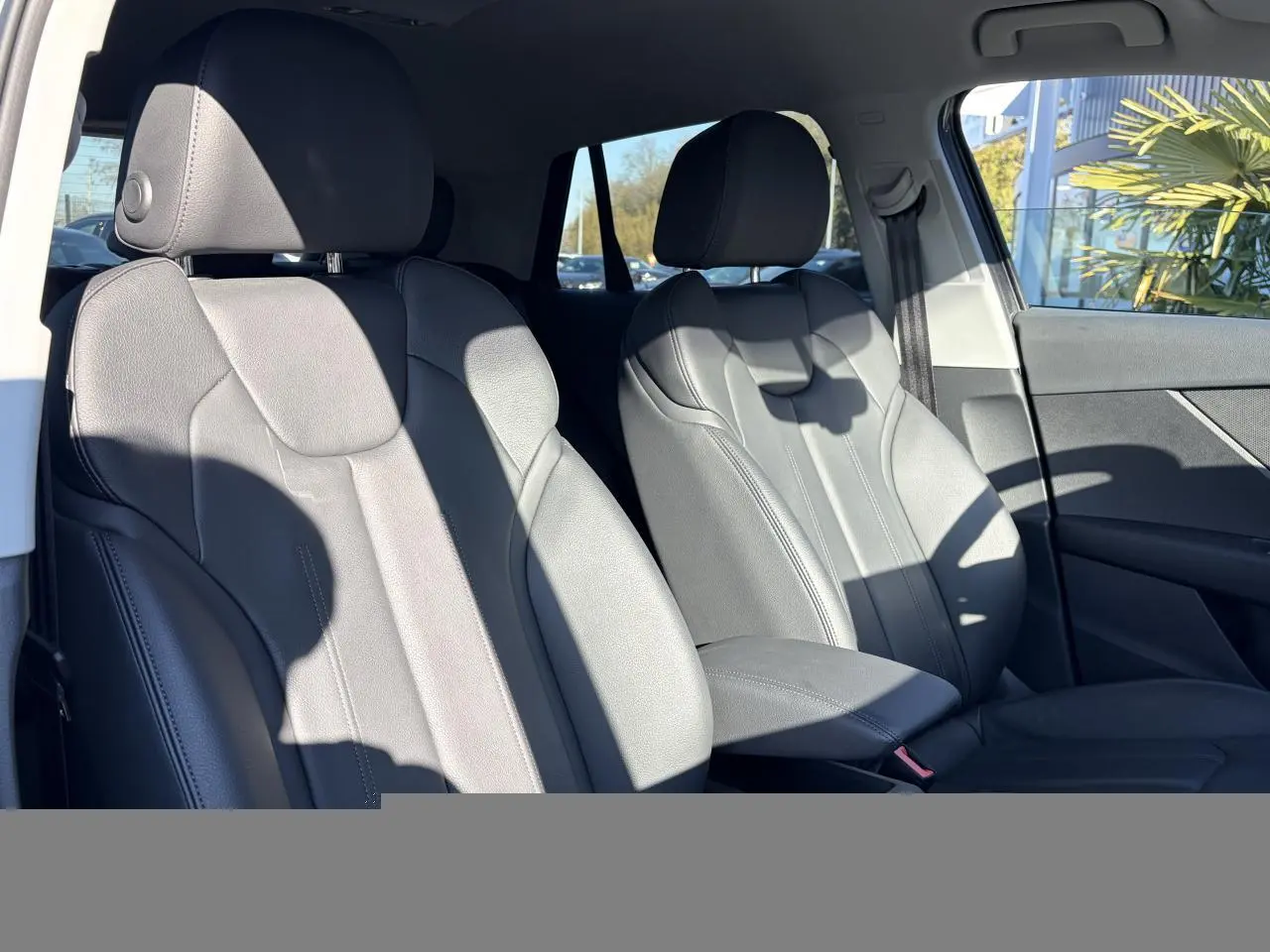 Vue intérieure des sièges avant en cuir gris de l'Audi Q2 35 TFSI S-Line, côté conducteur et passager.