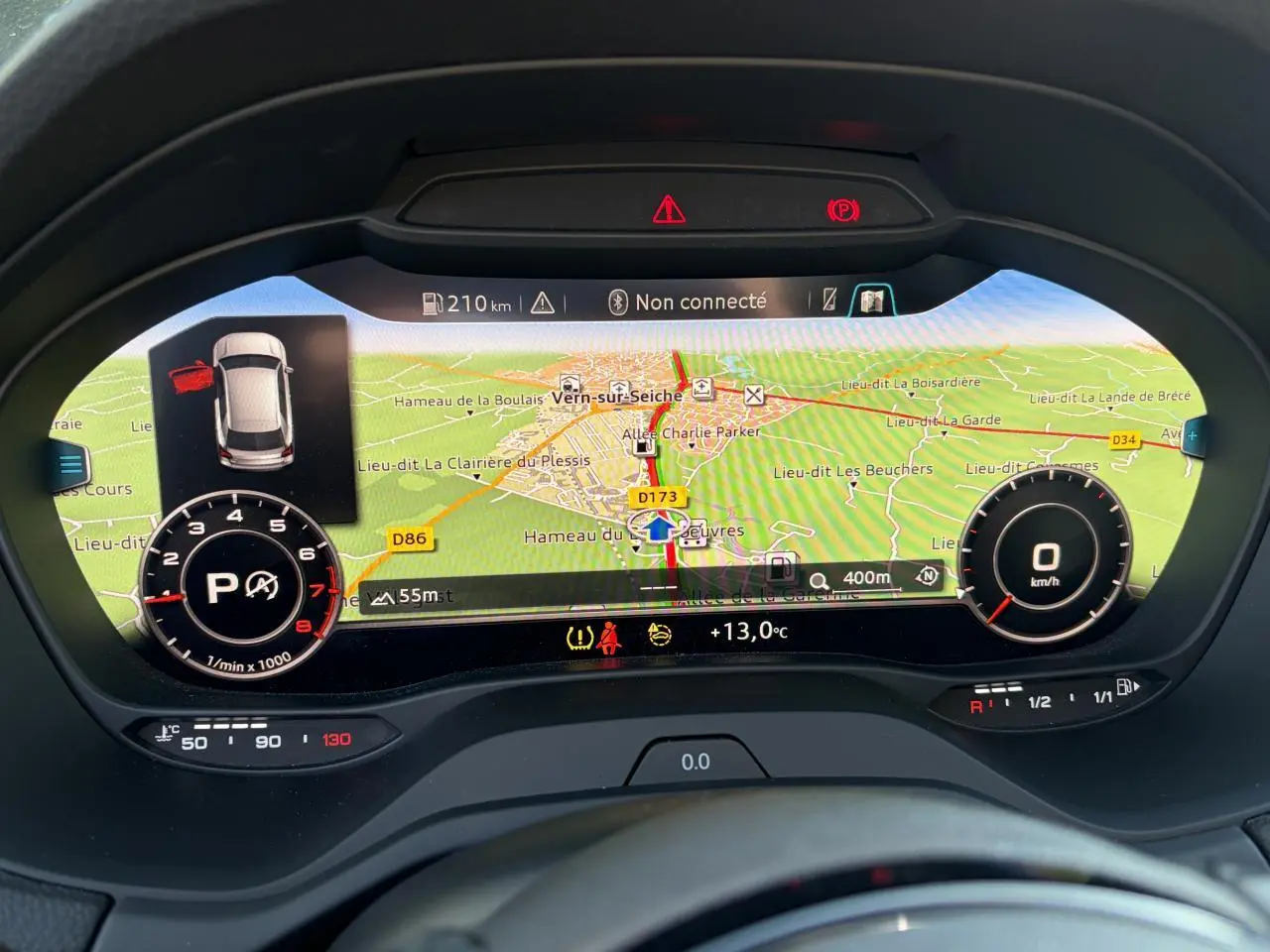 Affichage numérique du tableau de bord de l'Audi Q2 35 TFSI 2024 avec navigation et indicateurs de vitesse et régime moteur.