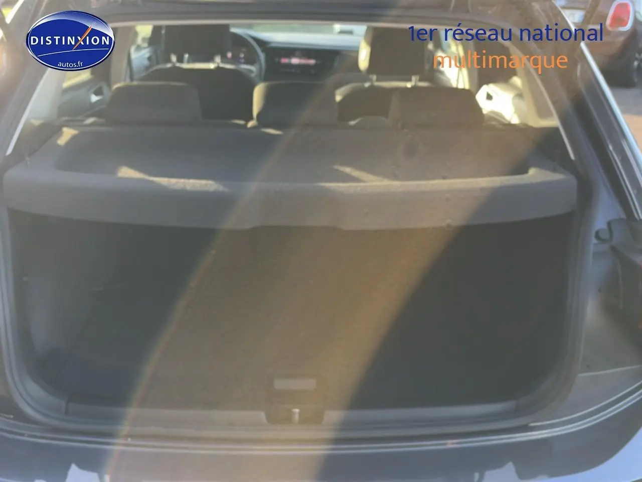 Vue arrière du coffre ouvert d'une Volkswagen Polo gris 2025, montrant l'intérieur et la tablette cache-bagages.