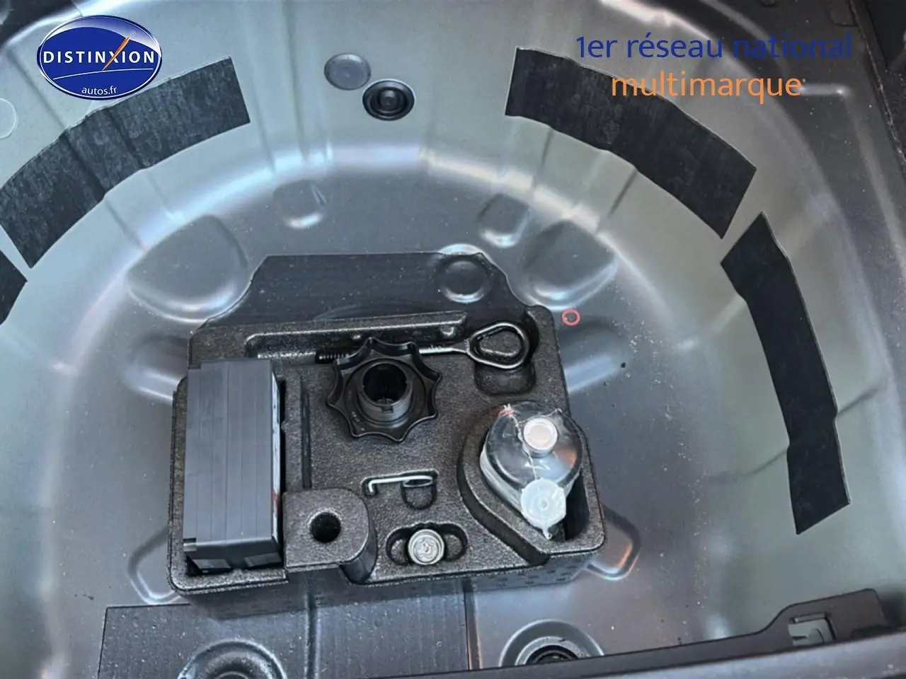 Vue plongeante sur le coffre gris d'une Volkswagen Polo 1.0 TSI 95 VW Edition, montrant le rangement pour roue de secours.