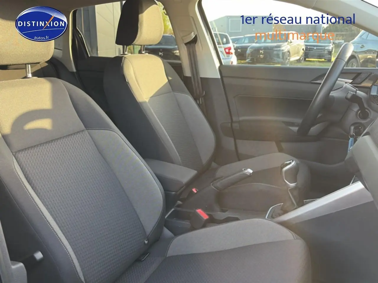 Vue intérieure côté droit montrant les sièges gris et la console centrale d'une Volkswagen Polo 2025 essence boîte manuelle.