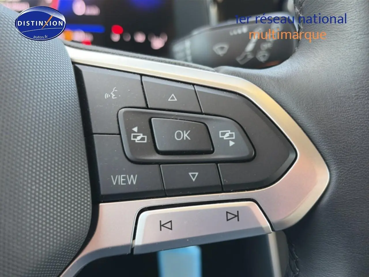 Gros plan sur les commandes multifonctions du volant cuir d'une Volkswagen Polo gris 2025, côté gauche.