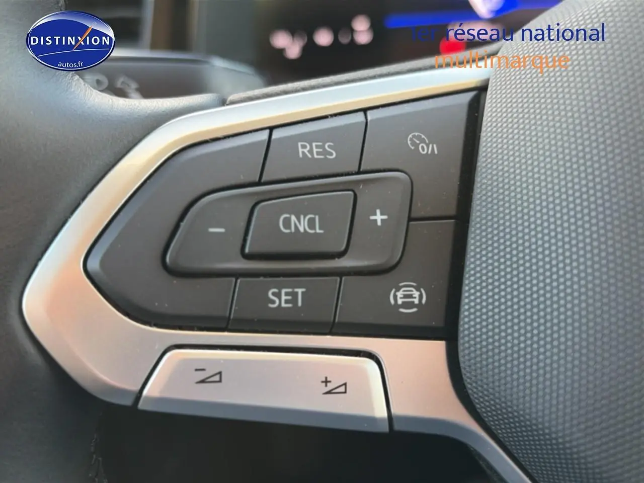 Gros plan sur les commandes du volant multifonction de la Volkswagen Polo gris 2025, avec boutons de régulateur de vitesse.