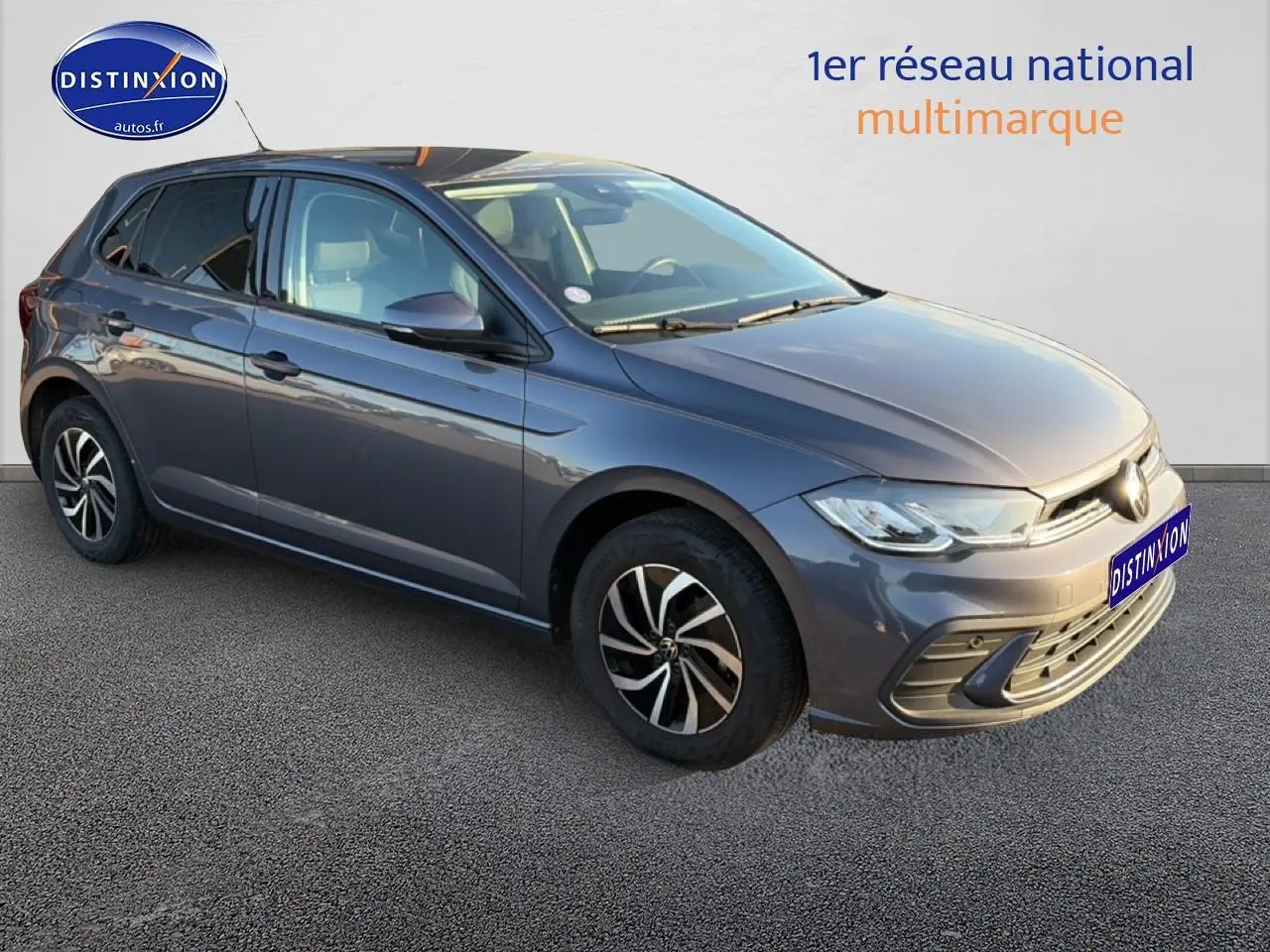 Volkswagen Polo gris vue 3/4 avant droit, avec jantes alu et phares LED allumés.