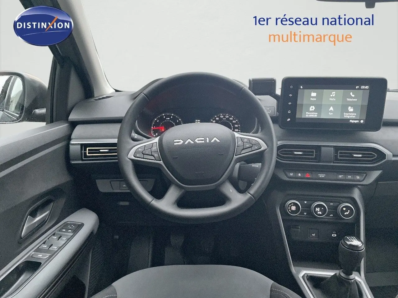 Intérieur du Dacia Jogger 2026 en vue frontale, volant multifonction, écran tactile et levier de vitesses manuel visibles.