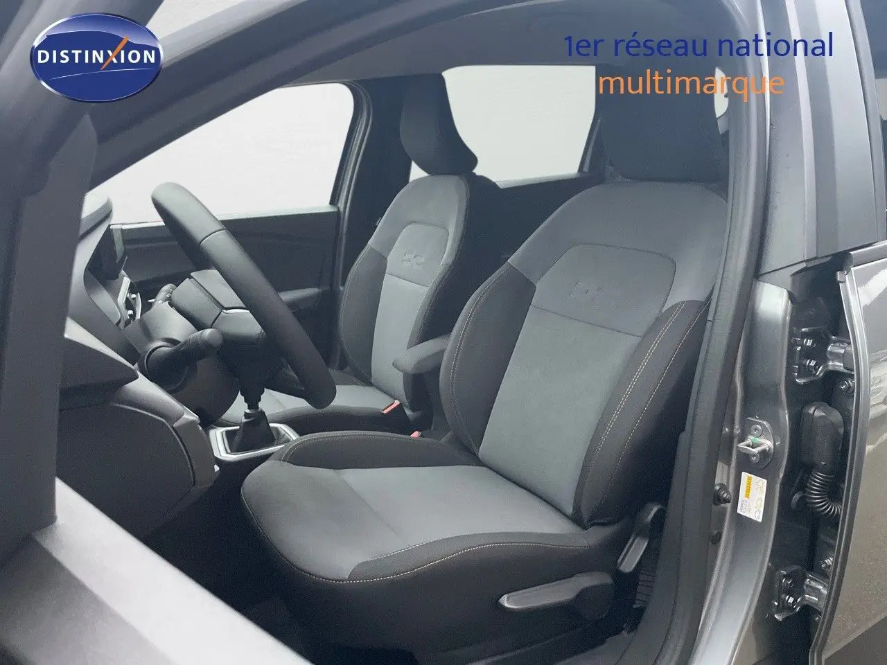 Vue intérieure côté conducteur du Dacia Jogger gris schiste métal, mettant en valeur les sièges tissu et alcantara avec coutures contrastantes.